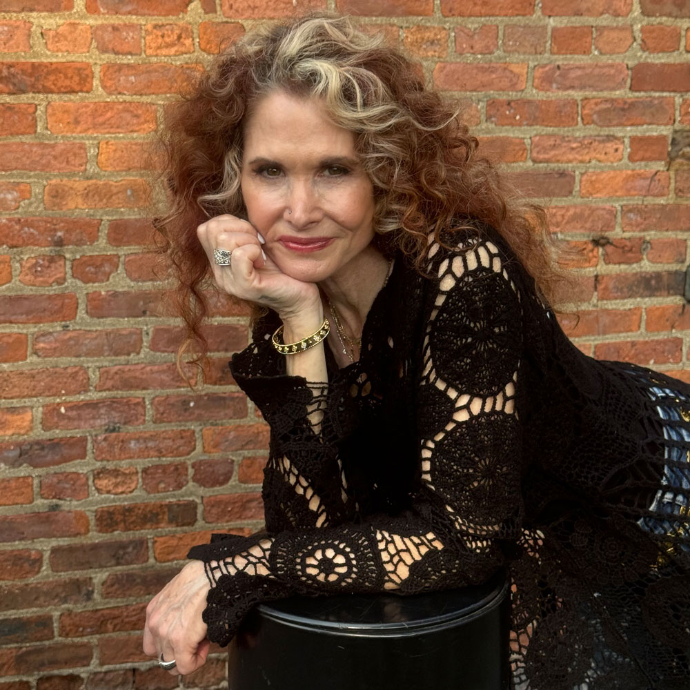 Photo of robyn posing in front of a brick wall 